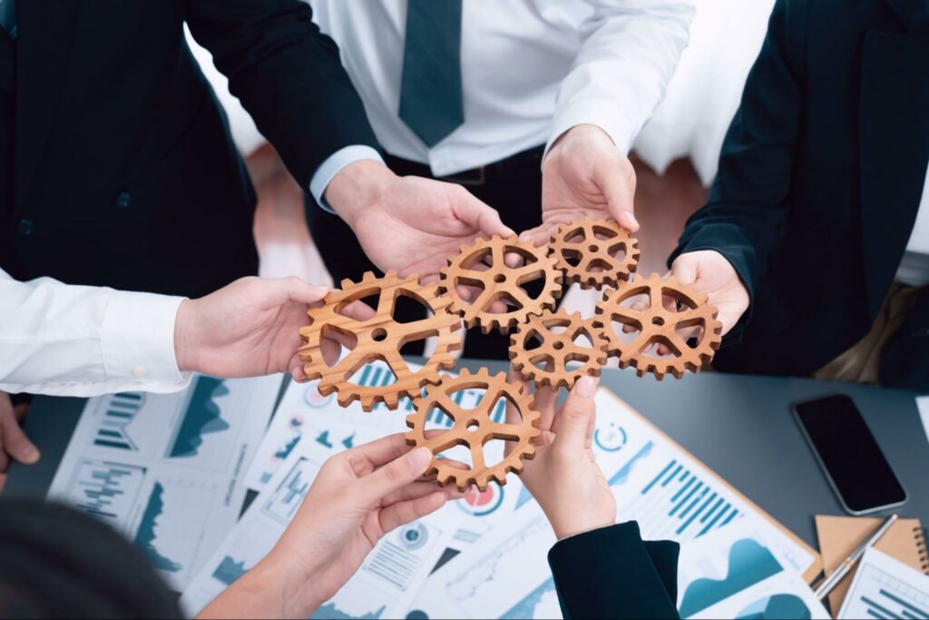 Éviter la faillite - Des professionnels collaborent en équipe pour mettre en place des stratégies efficaces, illustrées par des engrenages représentant la coordination et la gestion des finances d'une entreprise.